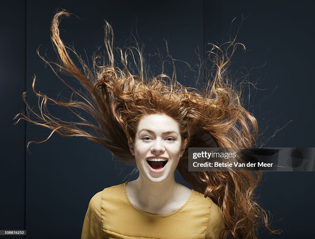 Woman laughing with her hair blowing in wind.