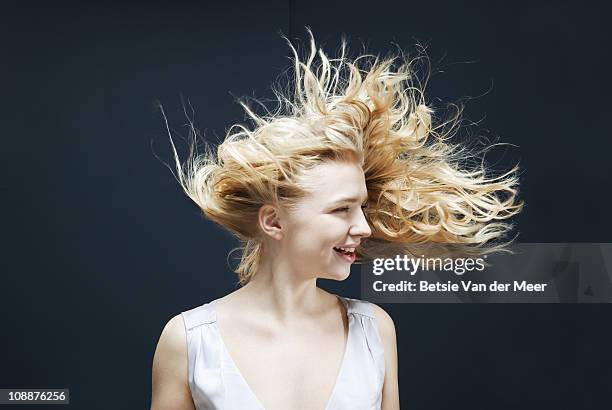 woman laughing with hair tossed in wind. - visage caché par les cheveux photos et images de collection