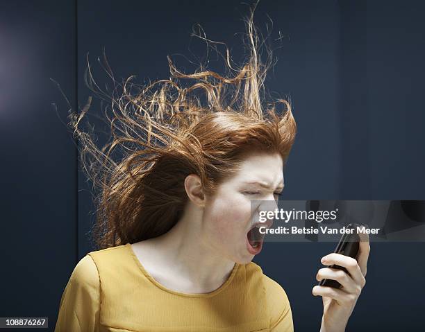 woman is shouting into phone. - rage stockfoto's en -beelden