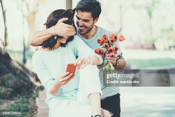 jeune homme surprenant sa copine avec bouquet de tulipes - fiançailles photos et images de collection