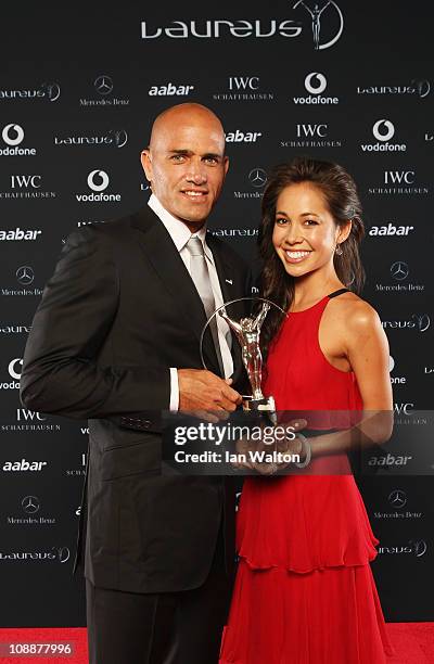 Surfer Kelly Slater of the United States and guest pose with his award for Laureus World Action Sportsperson of the Year in the winners studio at...