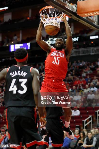 Kenneth Faried of the Houston Rockets dunks the ball defended by Serge Ibaka of the Toronto Raptors and Pascal Siakam in the first half at Toyota...