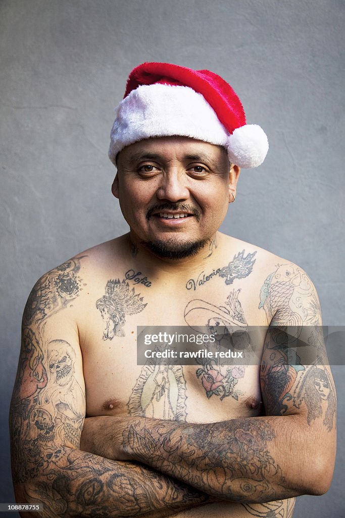 Tattooed man wearing Santa hat