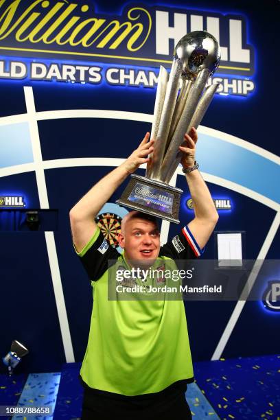 Michael van Gerwen of the Netherlands poses with the trophy after victory in the Final match against Michael Smith of England during Day 17 of the...