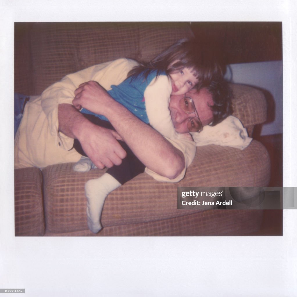 Polaroid of father and daughter hugging on couch