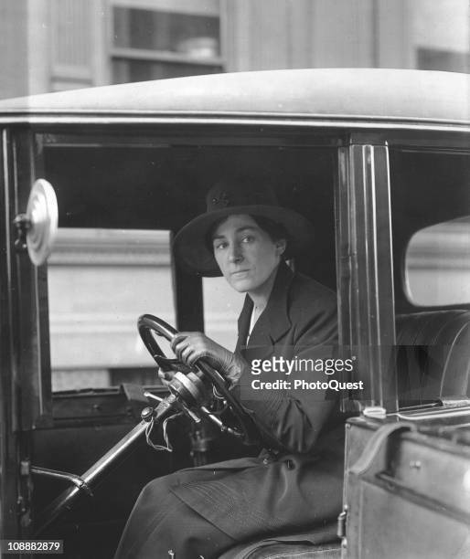 View of Philadelphia society matron, Mrs JL Ackerson, as she sits behind the wheel of an automobile, while acting as a chauffer for Fleet Hospital...