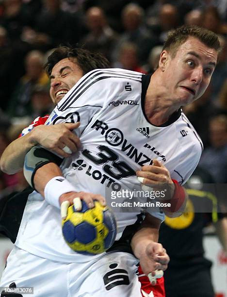 Filip Jicha of Kiel is challenged by Mark Schmetz of Ahlen during the Toyota Handball Bundesliga match between THW Kiel and HSG Ahlen at the...