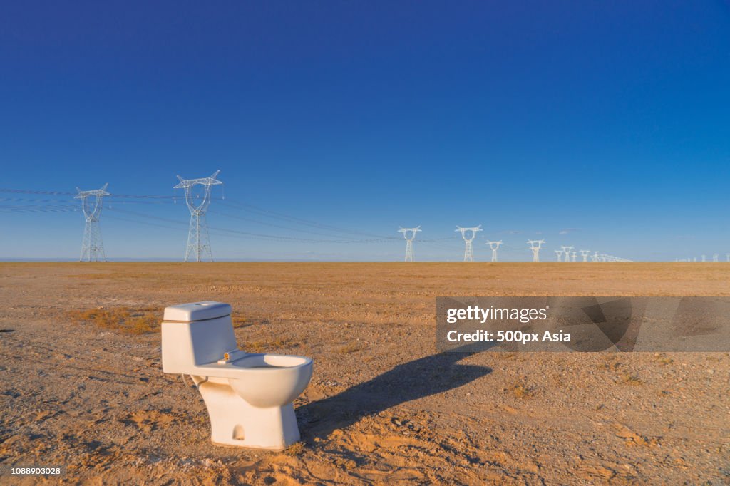 Toilet in barren field with power lines in background, Alxa League, Inner Mongolia Autonomous Region, China