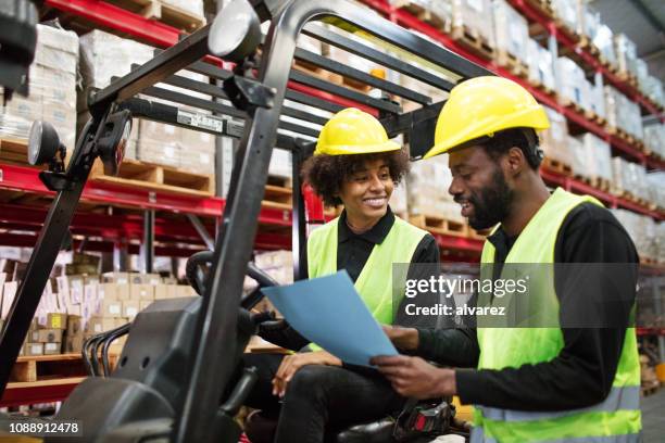 warehouse foreman discussing with forklift driver. - ware house worker forklift stock pictures, royalty-free photos & images