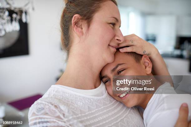 mother and teenage son embracing at home - proud parent stock pictures, royalty-free photos & images