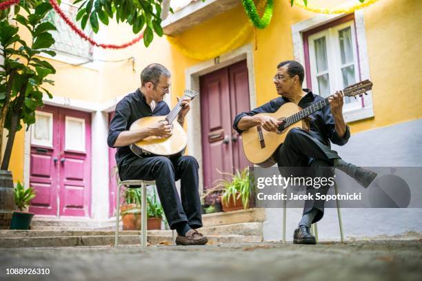 two fado guitarists with acoustic and portuguese guitars in alfama, lisbon, portugal - fado stock-fotos und bilder