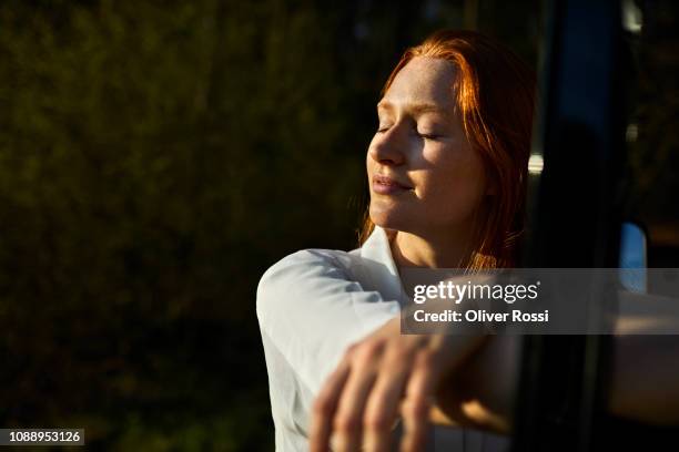 young girl in a rural landsape soaking up the sun - eyes closed stock-fotos und bilder