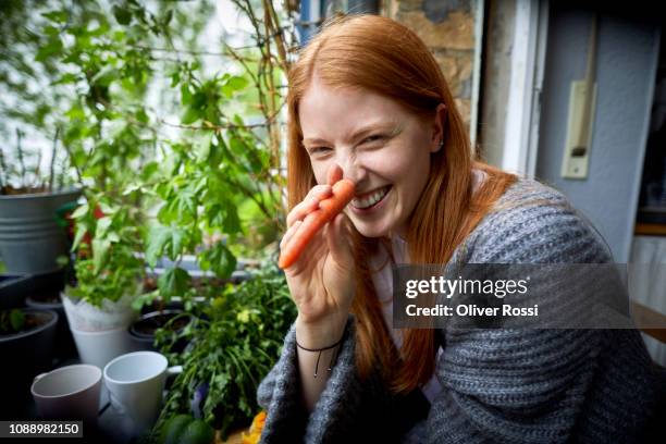 portrait of smiling young girl with carrot nose - long nose ストックフォトと画像