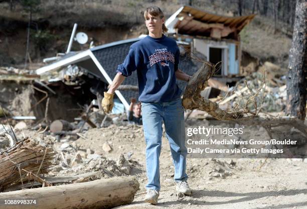 Volunteer Vicki Reynolds carries a branch from a tree while cleaning out debris from the Fourmile Creek on Saturday, Nov. 9, on Gold Run Road in...