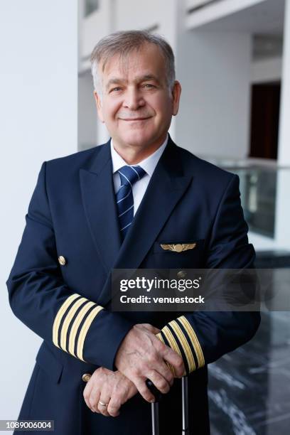 airplane pilot looking at camera and smiling - airline pilot imagens e fotografias de stock