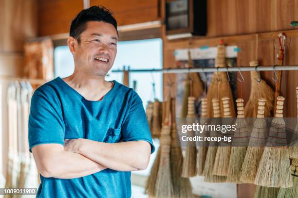 アジア人の男性が彼の作業スペースでほうきを作る - 職人 ストックフォトと画像