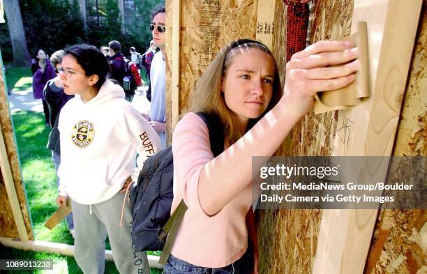 Sarah Good, a junior at the University of Colorado at Boulder, and a member of Hillel, uses sandpaper to remove two Nazi swastika emblems written...