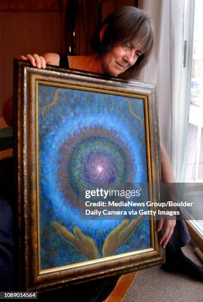 Clyde Rae Ashe holds a painting she calls "Healing Hands," which was painted by her husband Steve in 1997 shortly before he was diagnosed with and...