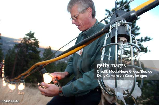 Craig Reynolds, CEO of Lord and Reynolds Electrical Services, Inc., replaces one of 40 broken lights in the Christmas Star on Flagstaff Mountain...