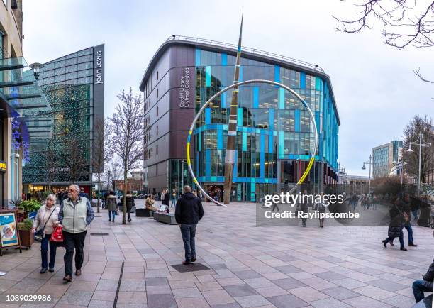 acquirenti e turisti che camminano vicino alla nave bandiera del gallese john lewis store e alla biblioteca di cardiff nel centro di cardiff, la capitale del galles - john lewis department store foto e immagini stock