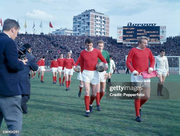 Manchester United captain Denis Law leads the team onto the field followed by David Herd and goalkeeper Harry Gregg prior to the start of the...