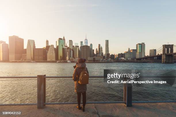 woman standing in front of manhattan, new york - museum of the city of new york winter ball stockfoto's en -beelden