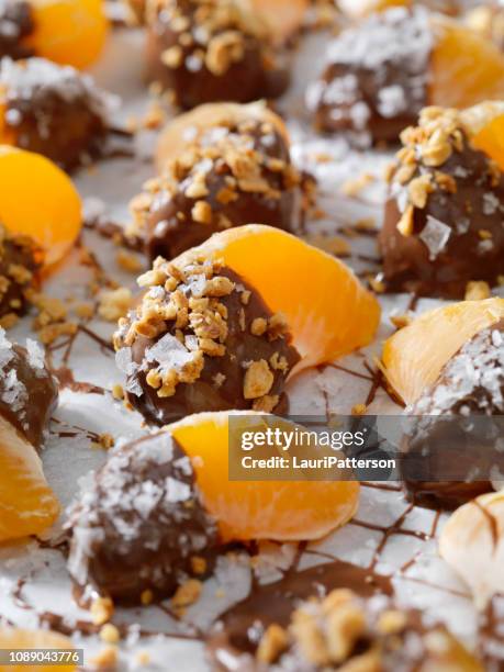 chocolate dipped oranges with roasted nuts and flake salt - mandarine stock pictures, royalty-free photos & images