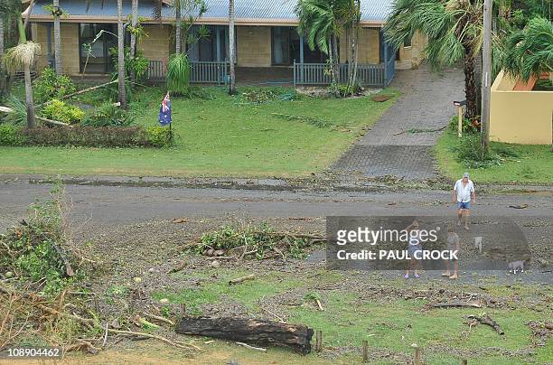 This aerial view shows residents outside their home damaged after Cyclone Yasi hit the Queensland coastal area of Mission Beach on February 3, 2011....