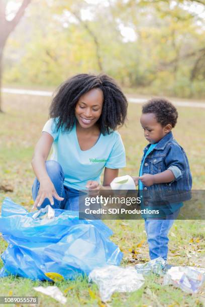 mom and son participate in community cleanup - picking up garbage stock pictures, royalty-free photos & images