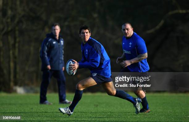 Wales flyhalf James Hook looks to pass the ball as coach Robert Howley and prop Craig Mitchell look on during Wales training at The Vale complex on...