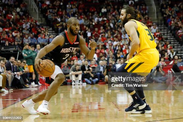 Chris Paul of the Houston Rockets drives to the basket defended by Ricky Rubio of the Utah Jazz in the second half at Toyota Center on December 17,...