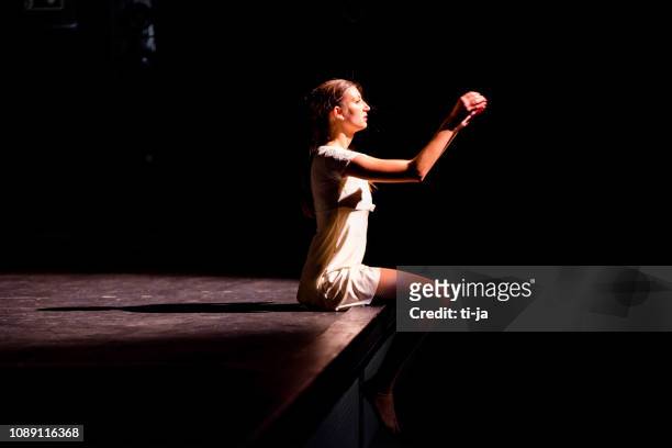 joven bailarina en el escenario de un teatro - performance fotografías e imágenes de stock