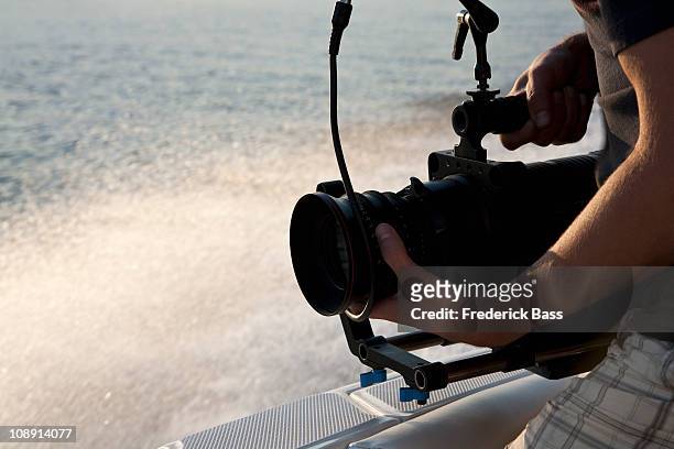 a cameraman filming on a motorboat - camera boat stock-fotos und bilder