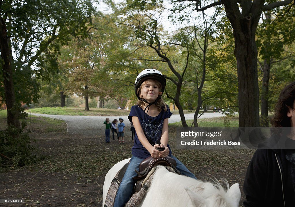 A young girl horseback riding