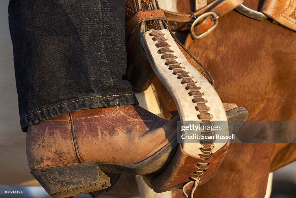 A cowboy boot in a horse stirrup, detail