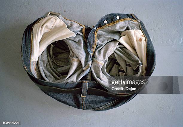 a pair of crumpled jeans on the floor - ceinture par dessus photos et images de collection