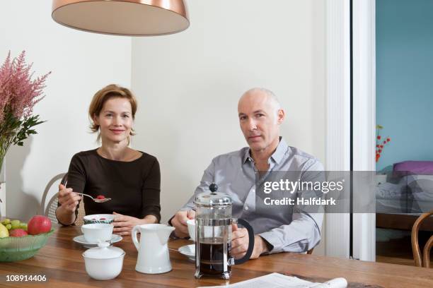a mature couple having breakfast together - besparen stockfoto's en -beelden