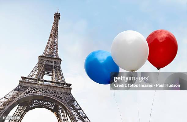 balloons in the colors of the french flag in front of the eiffel tower - bandera francesa fotografías e imágenes de stock