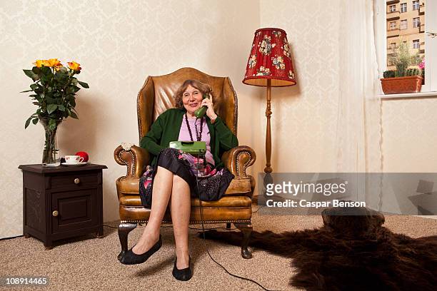a senior woman on the phone at home - legs crossed at knee stock pictures, royalty-free photos & images
