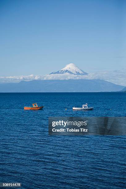 view of boats on lake llanquihue and osorno volcano, puerto varas, chile - puerto varas stock pictures, royalty-free photos & images