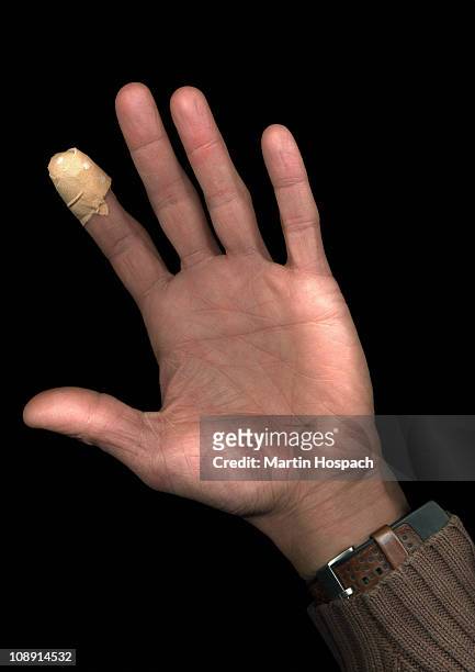 a man with a plaster on his finger, directly below, hand only - bandaged thumb stock pictures, royalty-free photos & images