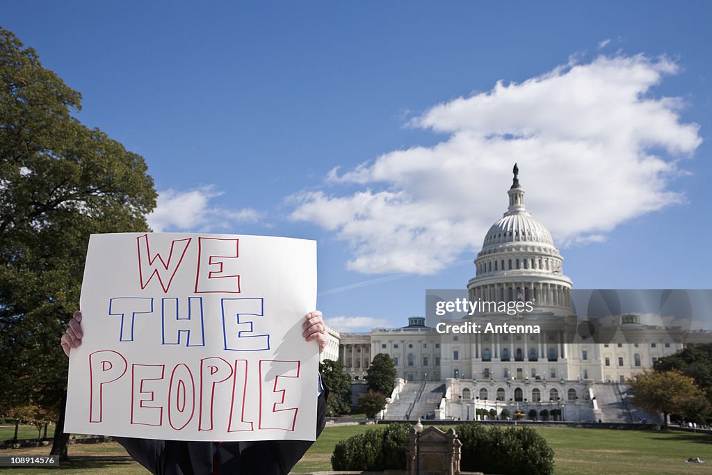 A protestor holding a placard in front of the US Capitol Building