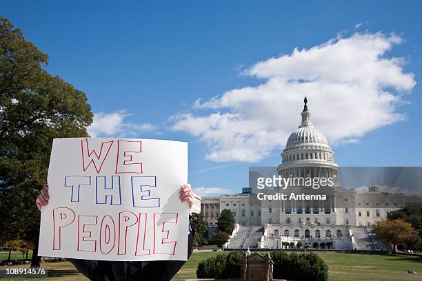 a protestor holding a placard in front of the us capitol building - constitution - fotografias e filmes do acervo