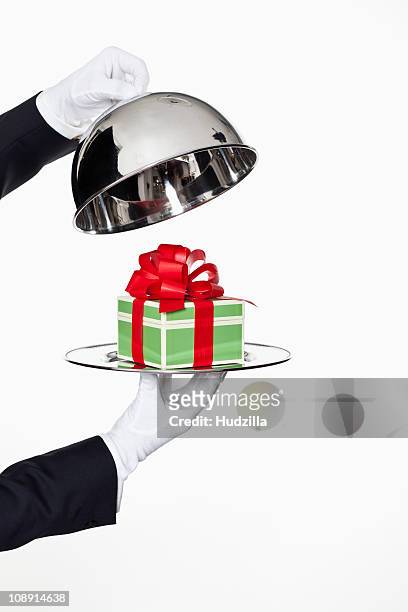 a butler taking the lid off a domed tray, revealing a gift, focus on hands - cloche stock pictures, royalty-free photos & images