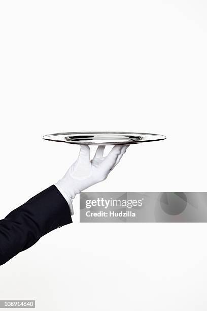 a butler presenting an empty silver tray, focus on hand - gray glove stock pictures, royalty-free photos & images