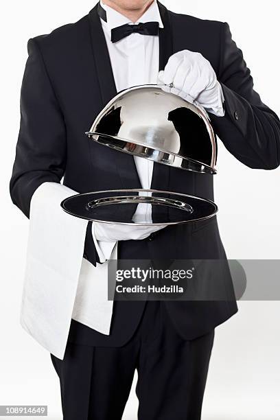 a butler taking the domed lid off an empty silver tray - gray glove stock-fotos und bilder