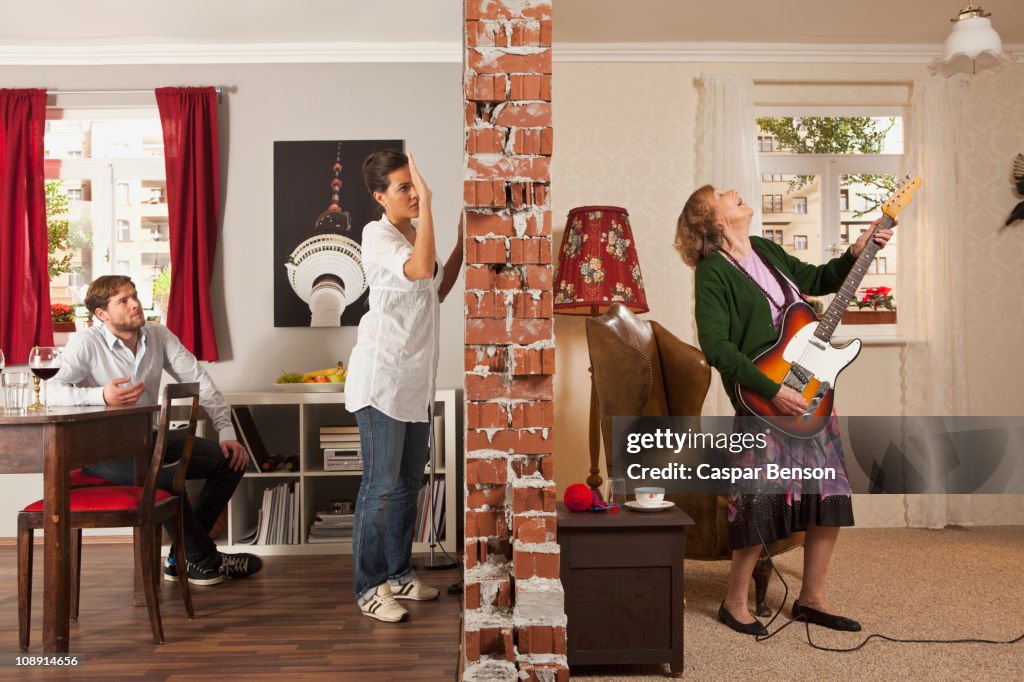 A split screen showing an angry woman pounding on the wall to her neighbor