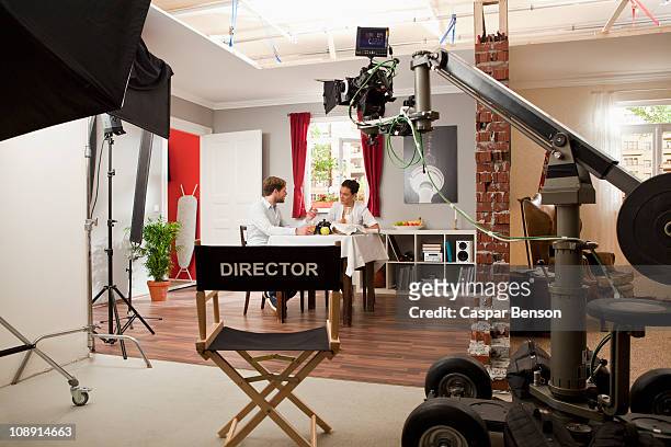 actors performing a scene on a film set - director's chair stock-fotos und bilder