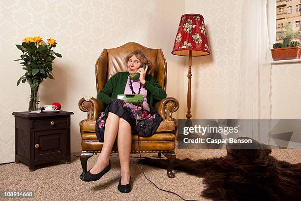 a senior woman gossiping on the phone - landline phone woman stock pictures, royalty-free photos & images