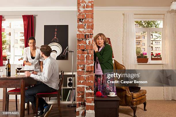 an senior woman listening to her neighbors arguing - ouvir às escondidas imagens e fotografias de stock